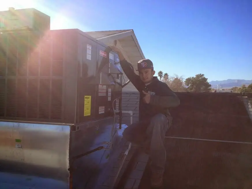 HVAC technician performing AC Tune-Up on a rooftop unit in Seaside